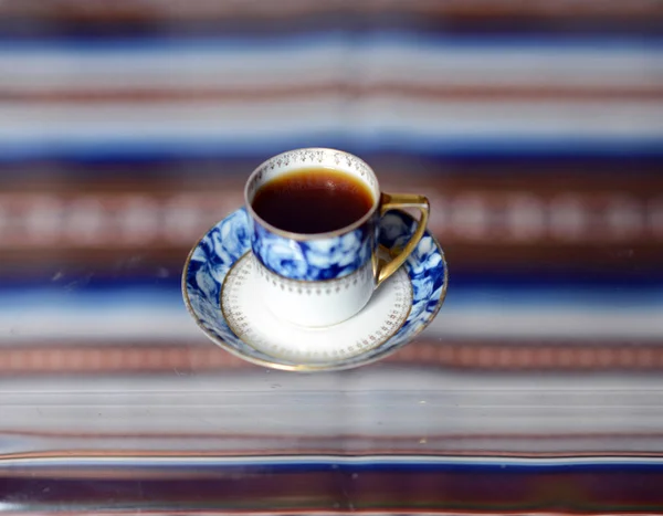 Una tazza con un delizioso caffè profumato costa su un tavolo di vetro . — Foto Stock