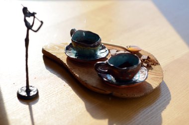 Bir fincan kahve ve çikolata bir ahşap stand hangi stand yanında duran kemancı heykelcik.