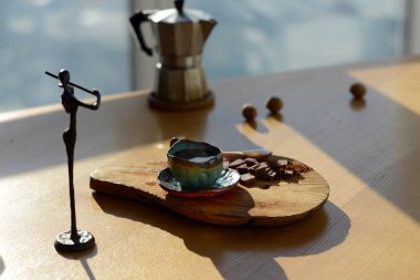 Bir fincan kahve ve çikolata bir ahşap stand hangi stand yanında duran kemancı heykelcik.