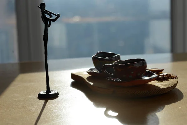 Bir fincan kahve ve çikolata bir ahşap stand hangi stand yanında duran kemancı heykelcik.