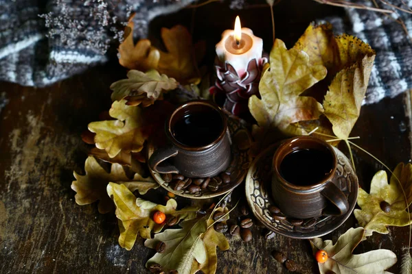 Kaffeetassen aus brauner Keramik. Kerze angezündet. — Stockfoto