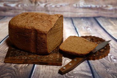 Taze pişmiş ekmek üzerinde keten masa örtüleri kokulu. Yakın bıçak yatıyor.