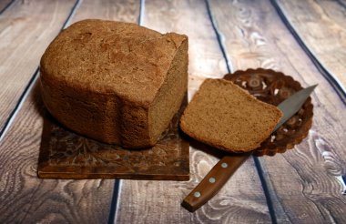 Taze pişmiş ekmek üzerinde keten masa örtüleri kokulu. Yakın bıçak yatıyor.