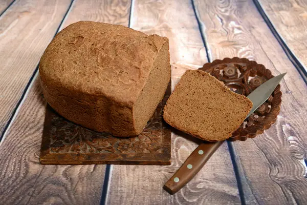 Φρεσκοψημένο ψωμί είναι αρωματικά για λινά τραπεζομάντιλα. Πολύ κοντά βρίσκεται και το μαχαίρι. — Φωτογραφία Αρχείου