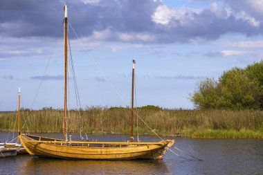 Küçük bir limanda, tahtadan yapılmış bir yelkenli manzarası.