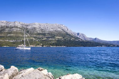 Limandaki Korcula ve Orebis şehirleri arasında çok güzel bir yelkenli gemisi var. Arka planda Peljesac dağları görülür. Hırvatistan
