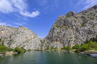 Dağa ve Adriyatik Denizi 'ndeki küçük limana bakın. Ön planda gemilerle küçük bir liman görünüyor. Omis, Hırvatistan 'ın Dalmaçya bölgesinde bulunan bir liman ve kasabadır..