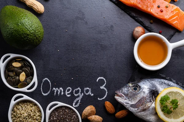 Black slate table with product rich in omega 3 and vitamin D. — Stock Photo, Image