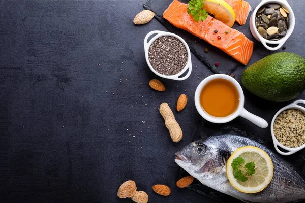 Table en ardoise noire avec un produit riche en oméga 3 et vitamine D . — Photo