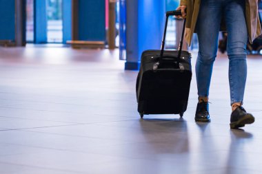 Havaalanında bavul çekerek kadınlar.