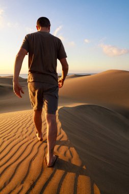 Maspalomas kum tepeleri arasında yürüyen adam. Gran Canaria ada.
