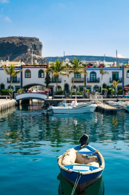 Puerto De Mogan Gran Canaria ada üzerinde renkli bağlantı noktası ile palmiye ağaçları.