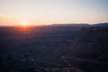 Dağlar ve kırsal alt yolda ile Kanyon yukarıda günbatımı.