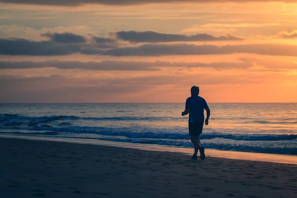 Człowiek Działa Przy Plaży Sunrise — Zdjęcie stockowe