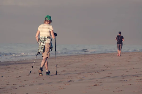Vecchia Donna Allenamento Nordic Walking Sulla Spiaggia — Foto Stock