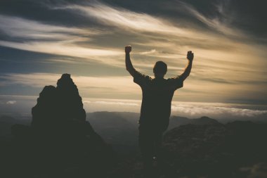Gran Canaria ada üzerinde dağda siluet adam kadar yükselterek eller.