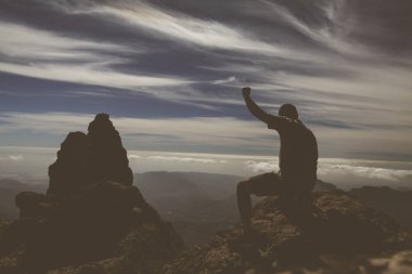 Gran Canaria ada üzerinde dağda siluet adam kadar yükselterek eller.