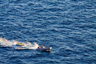 Adam lastik Motorlu tekne üzerinde kayak jet çekiyor.