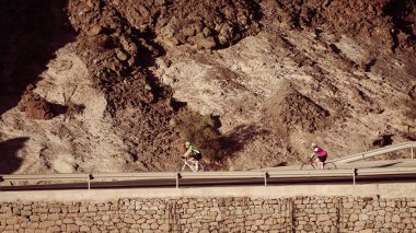 Çift bisikletçiler dağlar yolda sürme vardır.