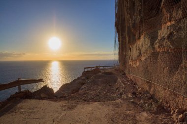 Kayalar düşüyor ve denizin altında kapalı dağ yolu üzerinde büyük çöküş delik.