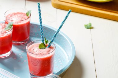 Taze karpuz smoothies, gözlük tahta masada duruyor.