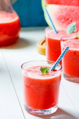 Taze karpuz smoothies, gözlük tahta masada duruyor.