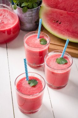 Taze karpuz smoothies, gözlük tahta masada duruyor.
