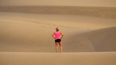 Kadın Maspalomas çölde duruyor.
