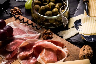 Şarapla peynir paleti ve prosciutto jambonu servis.