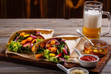 Tortilla tavuk ve sebze ve bira içmek. 