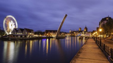 Akşamın şehir manzarasında inanılmaz ışıklar, Gdansk, Bascule yaya köprüsündeki Wapienny Köprüsü manzarası.
