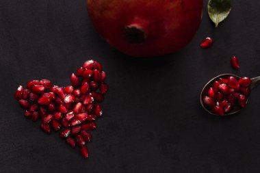 Karanlık manzarada nar tohumlarından yapılmış kalp şeklinde..