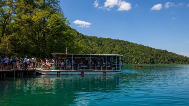 Hırvatistan 'ın Plitvice göl rıhtımındaki feribot tekneleri. İnsanlar Plitvice Gölleri Ulusal Parkı 'nı ziyaret ediyor