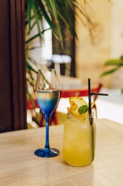 Kafedeki ahşap masada limonlu soğuk yaz içeceği. Yeşil yaprak doğası soyut arkaplan