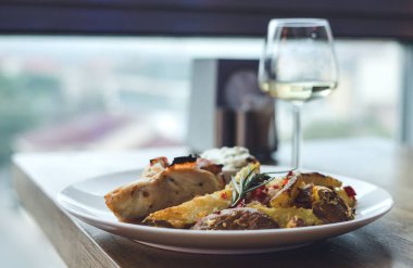 Restoranda sebzeli tavuk eti. Bir bardak beyaz şarap.