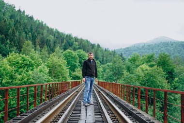 Güneşli bir günde tren yolunda bir adam.