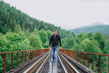 Güneşli bir günde tren yolunda bir adam.