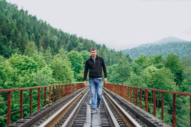 Güneşli bir günde tren yolunda bir adam.