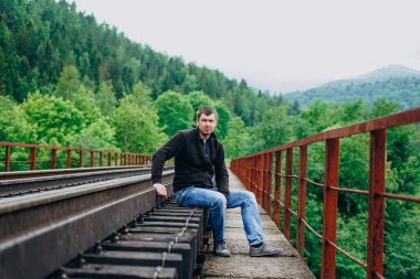 Ormanda demiryolunda yakışıklı bir adam.