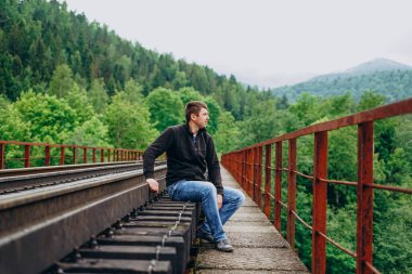 Ormanda demiryolunda yakışıklı bir adam.