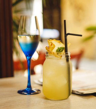 Kafedeki ahşap masada limonlu soğuk yaz içeceği. Yeşil yaprak doğası soyut arkaplan