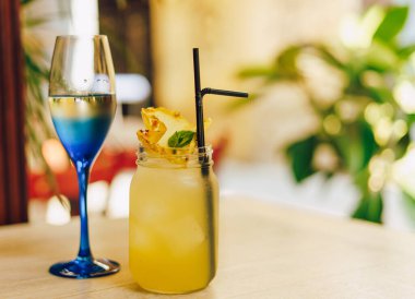 Kafedeki ahşap masada limonlu soğuk yaz içeceği. Yeşil yaprak doğası soyut arkaplan