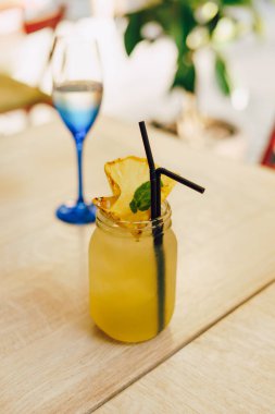 Kafedeki ahşap masada limonlu soğuk yaz içeceği. Yeşil yaprak doğası soyut arkaplan