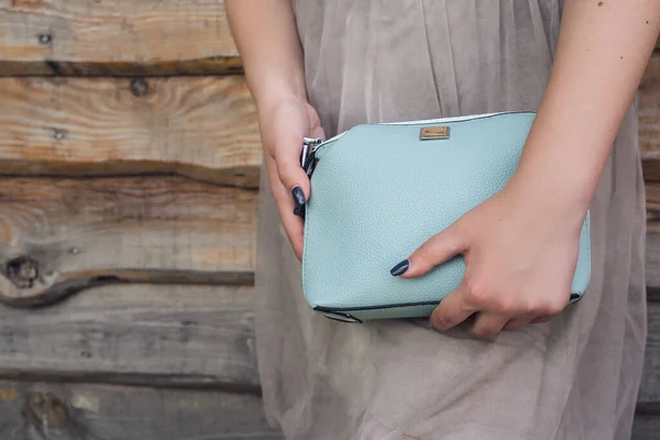 木製の背景に青のハンドバッグを保持女性 — ストック写真