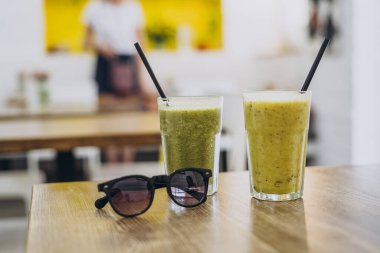 Yaz kafeteryasındaki masada bir bardak sağlıklı meyve püresi. Sebze suyu.