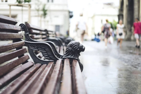 Wooden benches in the city center. Comfortable brown benches in the city. Wooden benches in old town in summer sunny day.