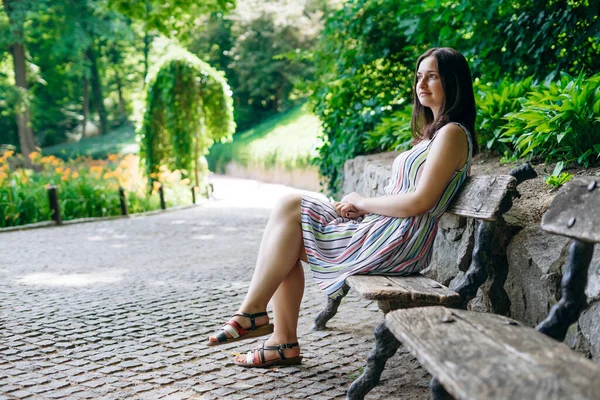 索菲亚公园 穿着夏天白色衣服的女游客在一个美丽的绿色公园里 女孩坐在园林绿化公园的木制长椅上 在夏日阳光灿烂的日子里 微笑的女孩在休息 — 图库照片
