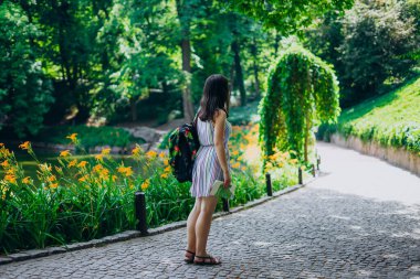 Sofia Park, Uman. Sırt çantalı genç bir kadın parkta yürüyor. Parktaki patikada elbisesi ve turist haritası olan bir kız. Sırt çantası ve tur haritası olan bir turist.