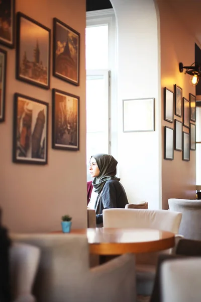 Muslimische Frau sitzt in Café — Stockfoto