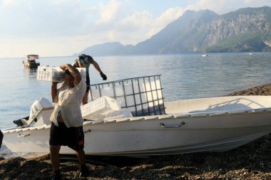işçiler bir tekneden balık kaldırma